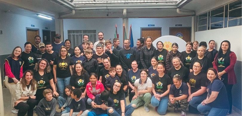 Foto em que aparecem várias pessoas posando dentro de uma escola, a Apae de Cândido de Abreu. A ...