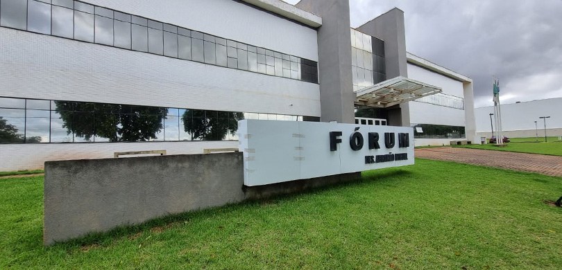 Foto da fachada do Fórum Estadual de Santa Fé. O edifício possui a fachada nas cores branca e ci...