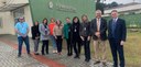 Fotografia de três homens e sete mulheres posando sorrindo em frente à fachada de um Fórum Eleit...