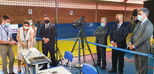 Foto do momento da totalização dos votos da eleição suplementar. À direita, há três homens em pé...