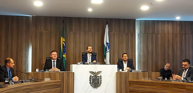 Fotografia em que aparecem seis homens sentados na mesa do plenário da Assembleia Legislativa do...