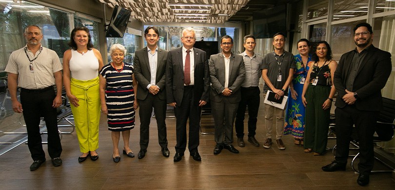 Foto em que aparecem quatro mulheres e sete homens posando em pé no terraço da Presidência do TR...