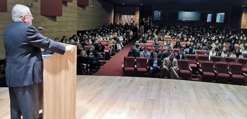 Foto tirado do palco de um auditório em direção a plateia. Do lado esquerdo, vê-se o desembargad...