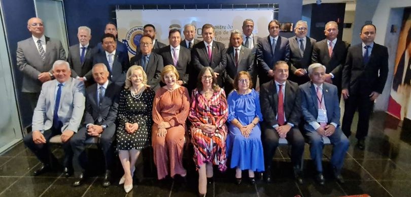 Fotografia dos presidentes dos TREs. Ao fundo, o banner de divulgação do evento. Um grupo de 15 ...