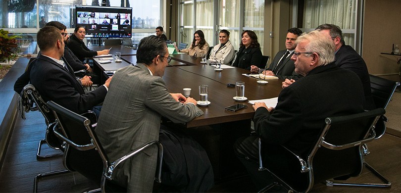 Foto da sala no terraço da Presidência, em que várias pessoas, entre homens e mulheres, estão se...