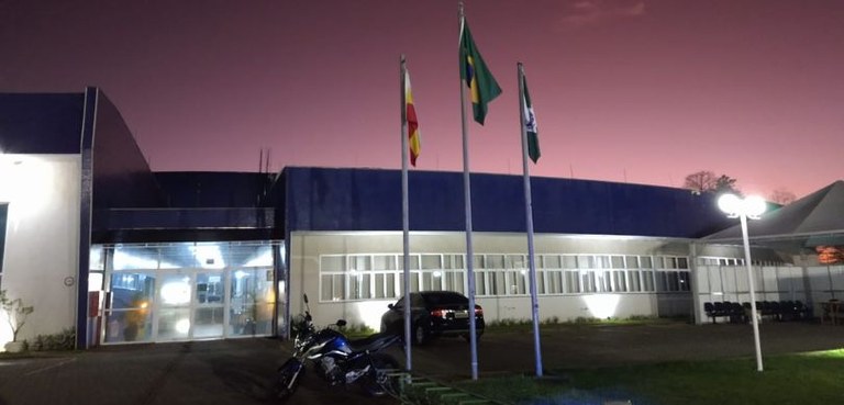 Foto em que se vê a fachada do Fórum Eleitoral de Maringá no entardecer. À frente, observam-se a...