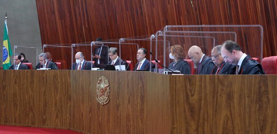 Foto de nove pessoas sentadas à uma mesa de autoridades.