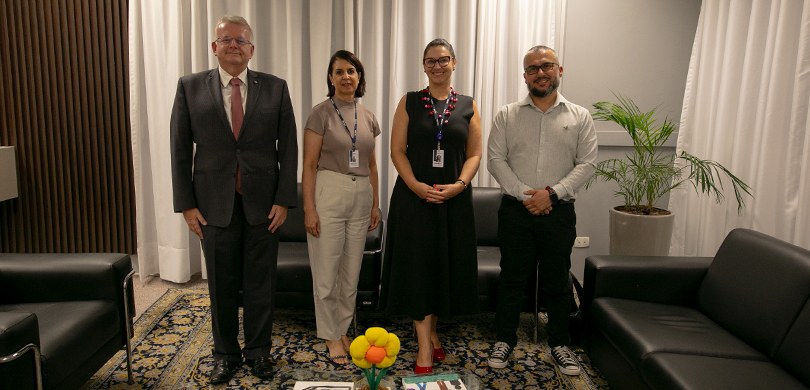 Fotografia em que aparecem posando em pé duas mulheres (ao centro) e dois homens no Gabinete da ...